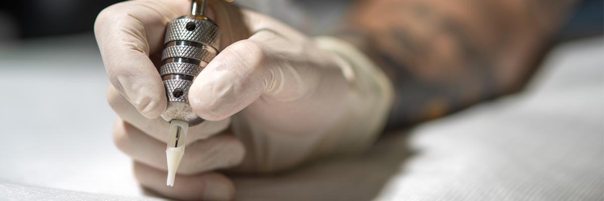 Una persona utiliza una máquina de tatuajes.